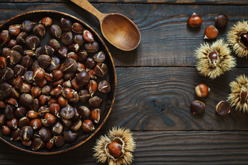 Roasted chestnuts in a pan and whole fruits