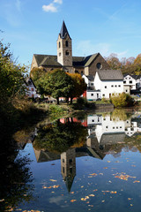 Fototapeta na wymiar Pfarrkirche St. Matthias spiegelt sich im Ulmener Maar