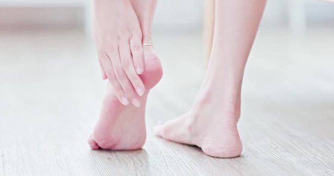 Woman applying cream onto foot