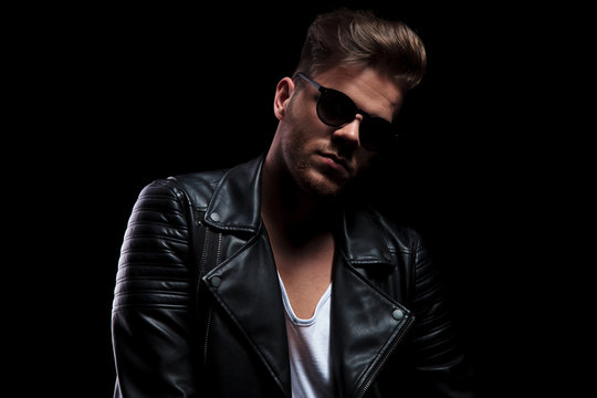 portrait of sexy man wearing black leather jacket and sunglasses