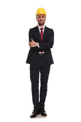 businessman wearing a safety helmet standing with hands folded