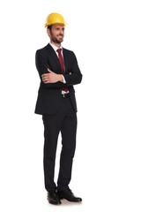 confident manager wearing a yellow construction cap looks to side