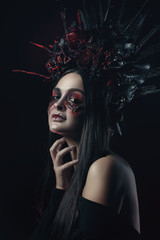 Terrible horror Halloween Vampire Woman portrait. Beauty Vampire Witch lady with blood on mouth posing in deep forest. Fashion Art design. holds a candle in his hands and reads curses