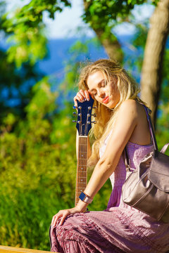 Girl with guitar outdoor on nature