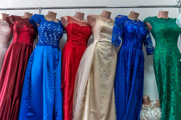 Colorful evening outfits on mannequins in salon