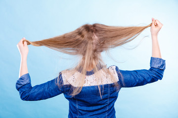 Blonde woman playing with hair.
