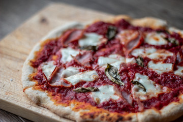 Delicious Italian pizza on a cutting board on dark background