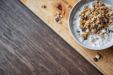 Bowl of chocolate muesli and milk on dark background
