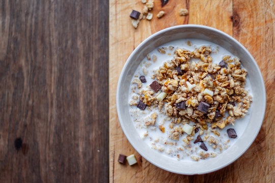 Bowl Of Chocolate Muesli And Milk On Dark Background