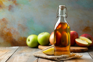 Apple vinegar. Bottle of apple organic vinegar or cider on wooden background. Healthy organic food....