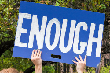 A protester holds sign ENOUGH at the March for Our Lives rally