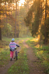 dziewczynka na rowerze w lesie. Piękna polska jesień