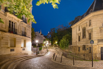 Empty cozy street and the Sacre-Coeur Basilica at night, quarter Montmartre in Paris, France