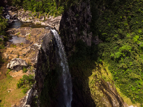 Aerial top view perspective of amazing 500 feet tall annamed waterfall in the tropical island jungle of Mauritius island.