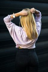 Photographing a girl during autumn near a high-tech glass building with a blurred background of the park