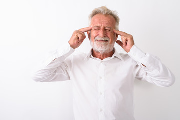 Studio shot of stressed senior bearded man having headache again