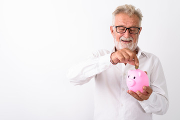 Studio shot of happy senior bearded man smiling while looking an