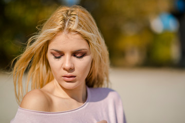 Photographing a girl during autumn on a beach near a river with a blurred background