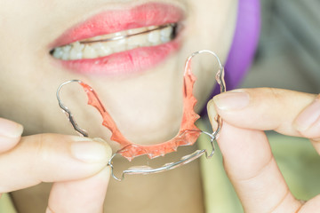 orthodontic retainer in patient's hand