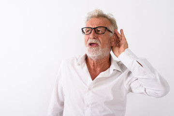 Studio shot of handsome senior bearded man listening while think