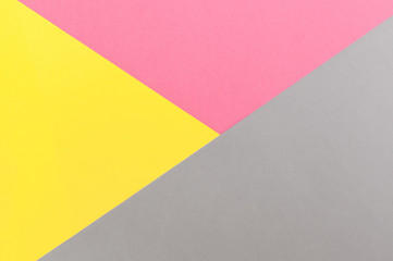 Bright, geometric gray-yellow-pink paper background with place for text. Abstract geometric festive background, flat lay
