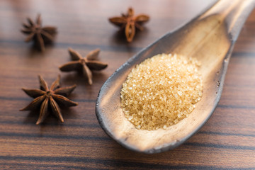 brown sugar in the spoon and anise on the table