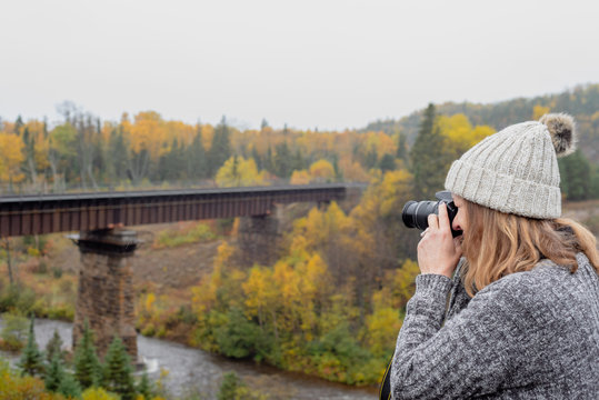 woman taking photo of bridge over river in Ontario Canada