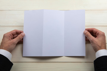 Obraz premium Mens hands holding empty white booklet