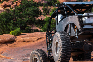 Fototapeta na wymiar A Custom 4x4 Rock Crawler Off-Roading In The Sandstone Red Rock Terrain Outside Of Moab Utah In The American Southwest
