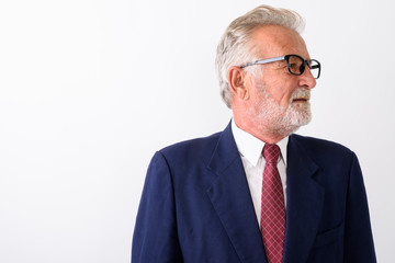 Profile view of handsome senior bearded businessman thinking and