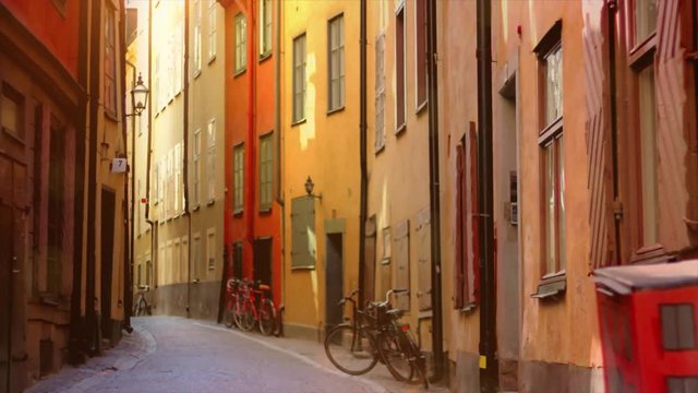 Colorful, traditional Swedish houses in tight street. Bike, sunshine and Nordic houses in Gamla Stan, Stockholm. 