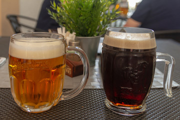 glass of beer and mug of beer on table