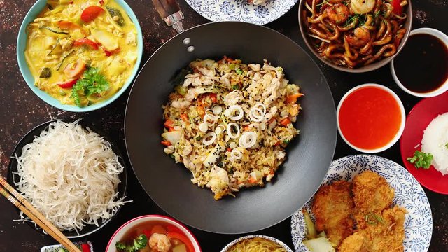 Asian oriental food composition in colorful dishware, served on dark rustic background, top view. Chinese, vietnamese, thai cuisine set. With copy space.