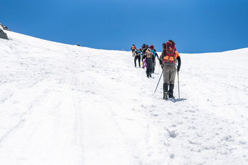 People doing trekking inside Andes valleys, crossing a snow valleys in central Chile at Cajon del Maipo, Santiago de Chile, amazing views over mountains and glaciers with awesome hiking exploration