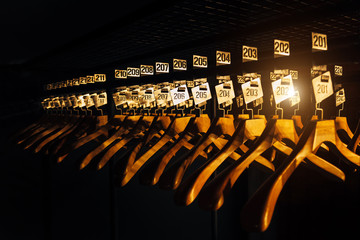 Wooden hangers with numbers in dark cloakroom