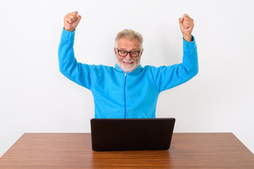 Studio shot of happy senior bearded man smiling while looking ex
