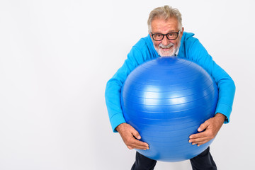 Studio shot of happy senior bearded man smiling while standing a