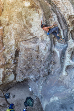 The last movements to reach the summit by a male climber. Rock climbing inside the Andes mountains at Cajon del Maipo, Chile. Climber solving the movements of "Annunaki" route a 8b french difficulty