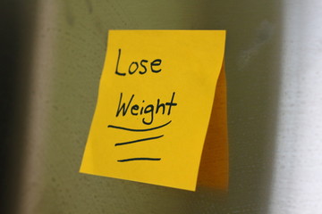 a note saying Lose weight that is sticky on the fridge