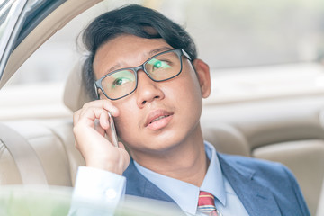 Businessman working in backseat of a car