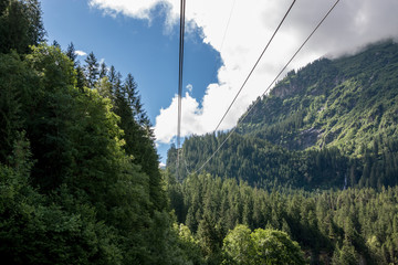 Closeup mountains scenes, cable car to Trift Bridge in national park Switzerland, Europe. Summer landscape, sunshine weather, cloudy sky and sunny day