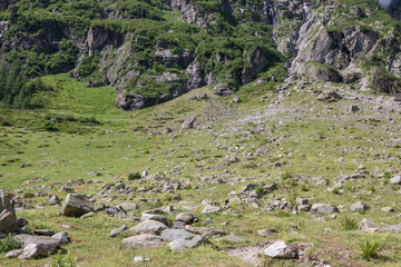 Closeup mountains scenes, walk to Trift Bridge in national park Switzerland, Europe. Summer landscape, sunshine weather, dramatic cloudy sky and sunny day