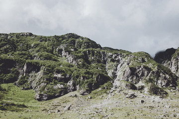 Closeup mountains scenes, walk to Trift Bridge in national park Switzerland, Europe. Summer landscape, sunshine weather, dramatic cloudy sky and sunny day