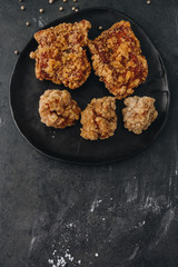 Chicken karaage japanese food in the black plate on grey concrete background with herb and flour