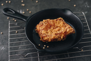 Chicken karaage japanese food in the pan on grey concrete background with herb and flour