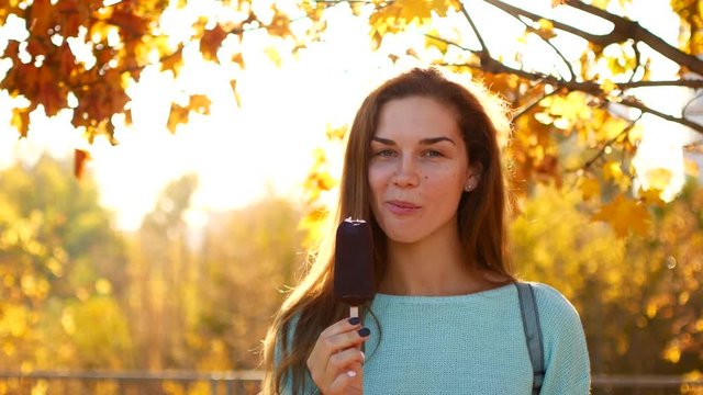 Woman Eating Ice Cream in Autumn Park