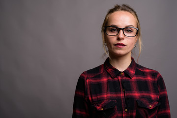 Obraz premium Young beautiful woman with blond hair wearing eyeglasses against