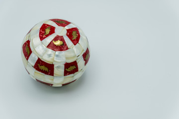 Red and white marble Christmas ball with golden images.