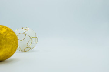 Golden glittered and white christmas balls on white.