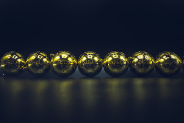Golden Christmas balls on black background.